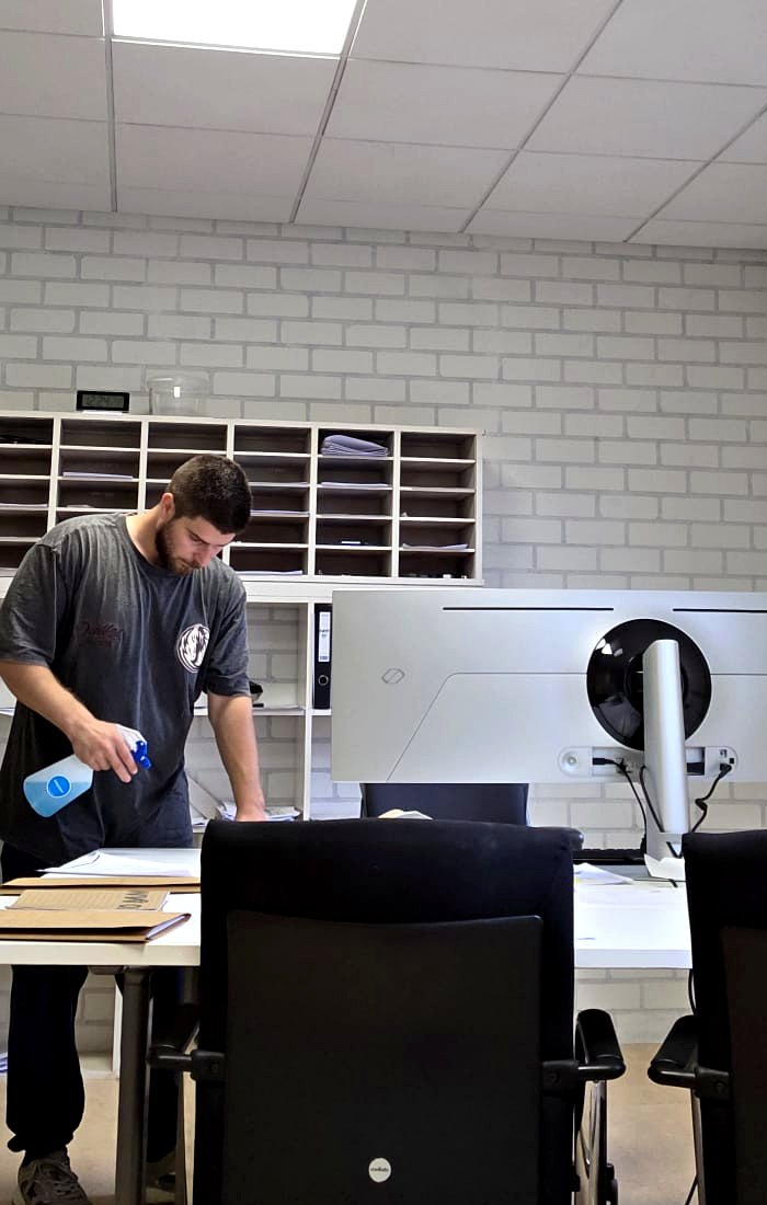 Werkplekken en bureaus worden gereinigd tijdens de kantoorschoonmaak